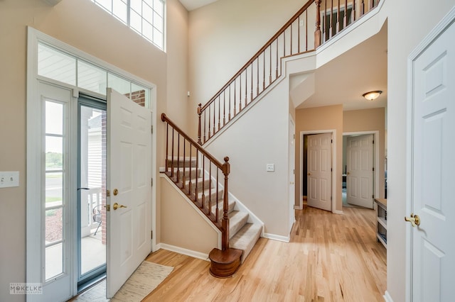 241 Morgan Valley Dr, Oswego, IL 60543 - entrance foyer featuring wood finished floors, plenty of natural light, a high ceiling, stairs, and baseboards