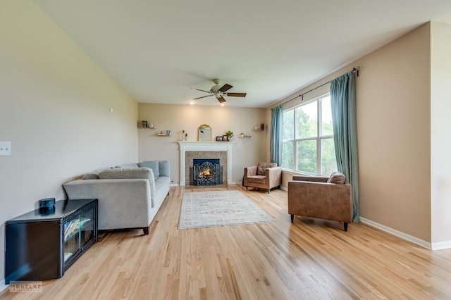 241 Morgan Valley Dr, Oswego, IL 60543 - living room featuring a ceiling fan, light wood finished floors, a fireplace with flush hearth, and baseboards