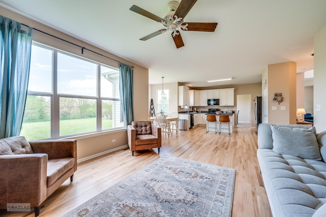 241 Morgan Valley Dr, Oswego, IL 60543 - living room with a ceiling fan, light wood finished floors, and baseboards