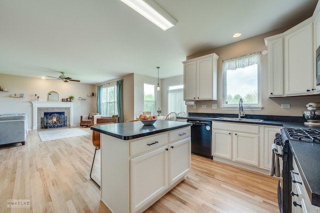 241 Morgan Valley Dr, Oswego, IL 60543 - kitchen with a sink, dishwasher, gas range oven, dark countertops, and light wood-style flooring