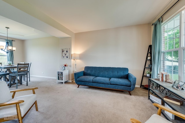 241 Morgan Valley Dr, Oswego, IL 60543 - living room with healthy amount of natural light, baseboards, a chandelier, and carpet flooring