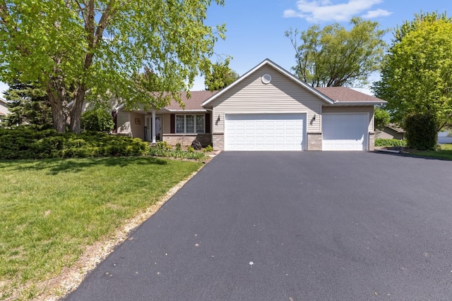 ranch-style home with a garage, brick siding, driveway, and a front yard