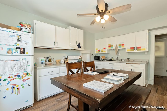 10208 N Main St, Richmond, IL 60071 - kitchen with freestanding refrigerator, wood finished floors, light countertops, a ceiling fan, and white cabinetry