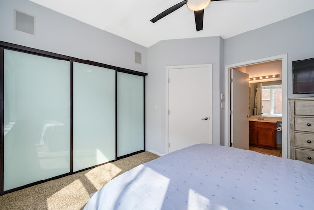 bedroom with a closet, light carpet, connected bathroom, ceiling fan, and baseboards