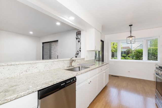 kitchen with stainless steel appliances, a sink, light wood-style floors, white cabinetry, and baseboards
