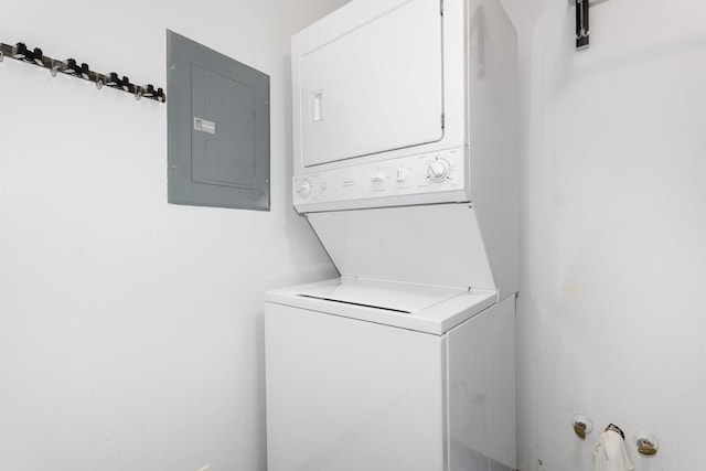 laundry area featuring electric panel and estacked washer and dryer