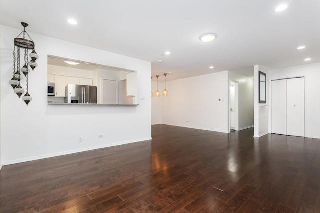 unfurnished living room with dark wood finished floors, recessed lighting, and baseboards