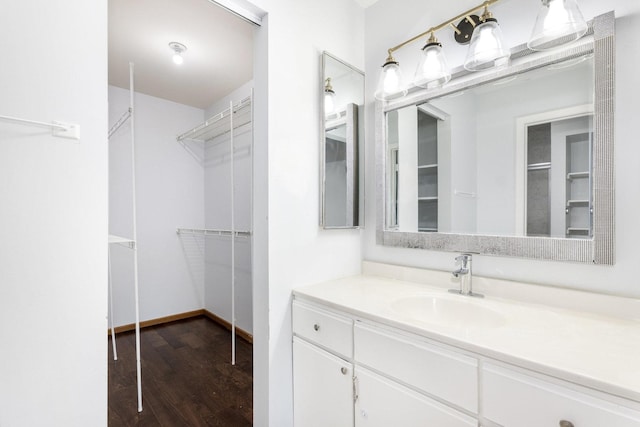 full bath featuring a walk in closet, wood finished floors, and vanity