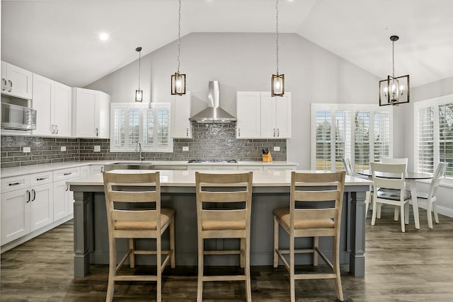 8081 Tennessee Ave, Willowbrook, IL 60527 - kitchen featuring wall chimney exhaust hood, stainless steel microwave, a sink, light countertops, and high vaulted ceiling