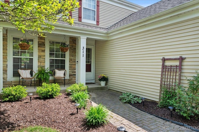 311 Mayfair Ln, South Elgin, IL 60177 - view of exterior entry with covered porch, roof with shingles, and stone siding