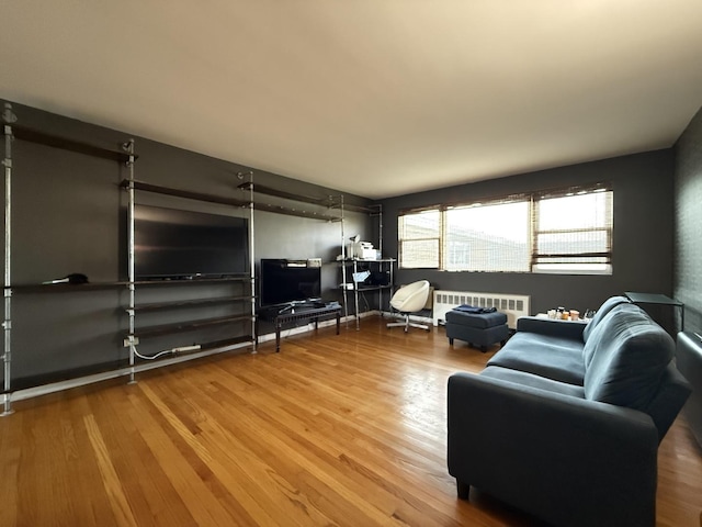 living area with radiator and wood finished floors