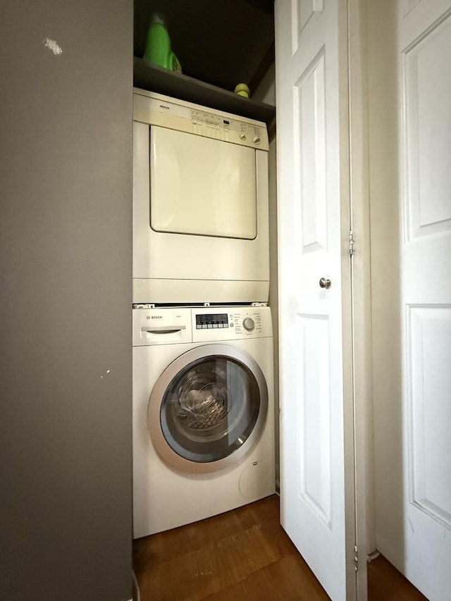 laundry room featuring stacked washing machine and dryer and wood finished floors