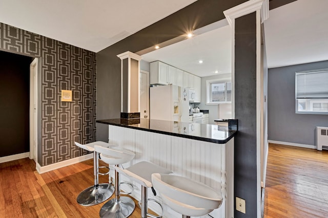 7435 N Ridge Blvd Unit 3B, Chicago, IL 60645 - kitchen featuring white appliances, baseboards, white cabinets, radiator, and light wood-style flooring
