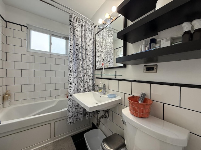 bathroom with toilet, tile walls, a sink, and shower / bath combo