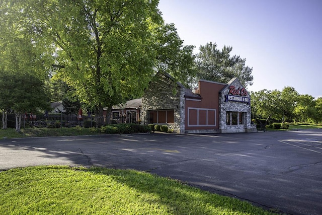view of front of property with stone siding and uncovered parking