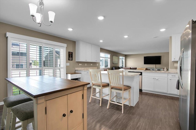 6103 Winterhaven Dr, Joliet, IL 60431 - kitchen with freestanding refrigerator, a center island, a breakfast bar, open floor plan, and dark wood-style floors