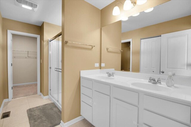 6103 Winterhaven Dr, Joliet, IL 60431 - full bath with a shower stall, double vanity, a walk in closet, tile patterned floors, and baseboards