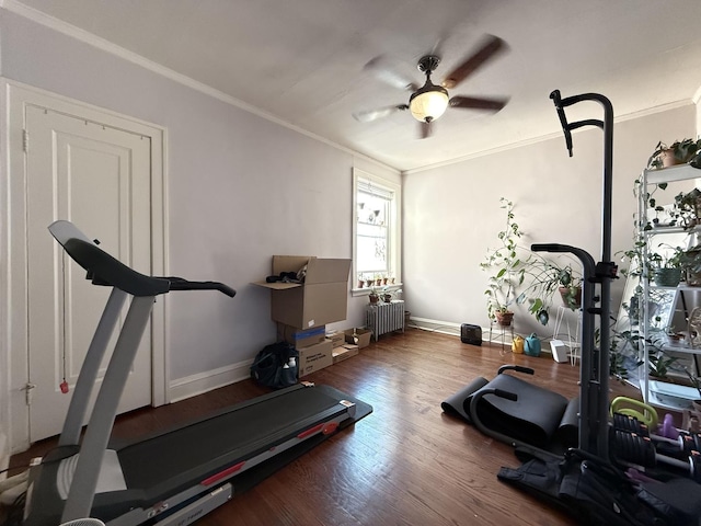 exercise area with radiator heating unit, a ceiling fan, crown molding, baseboards, and wood finished floors