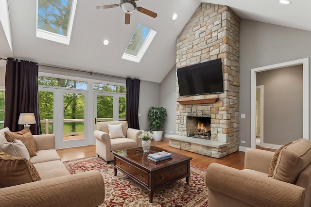 1302 Bradley Ct, Spring Grove, IL 60081 - living area featuring high vaulted ceiling, a skylight, ceiling fan, wood finished floors, and a stone fireplace