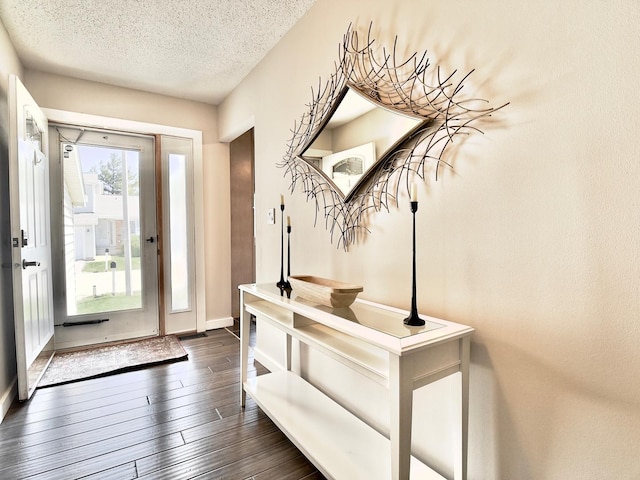 entrance foyer with a textured ceiling, dark wood finished floors, and baseboards