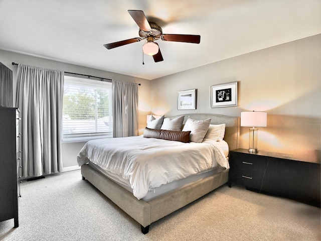 bedroom featuring light carpet, ceiling fan, and baseboards