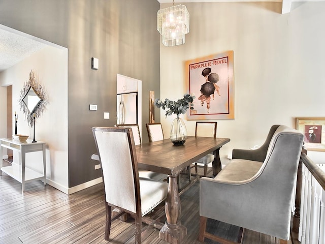 dining room with wood finished floors, baseboards, and a chandelier