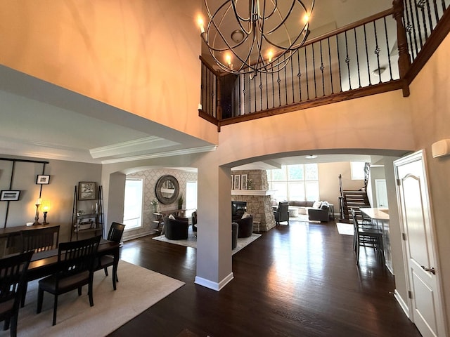 12074 Winterberry Ln, Plainfield, IL 60585 - foyer entrance featuring arched walkways, wood finished floors, a chandelier, crown molding, and a fireplace