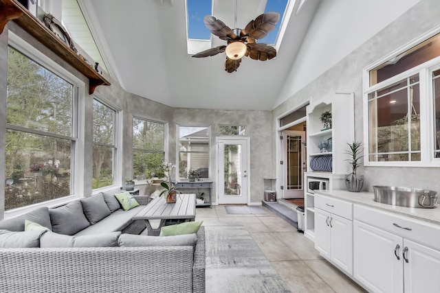 sunroom / solarium featuring healthy amount of natural light, high vaulted ceiling, and baseboards