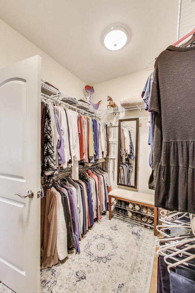 walk in closet with wood finished floors