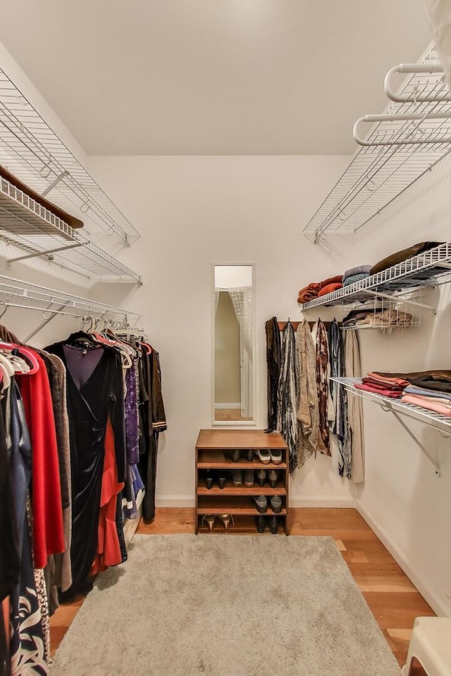 walk in closet with wood finished floors