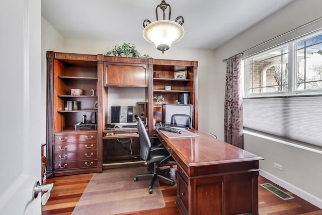 office space with wood finished floors and baseboards