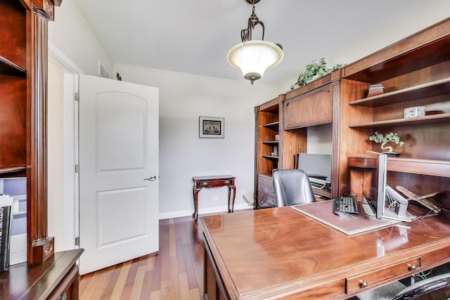 office area with dark wood finished floors and baseboards