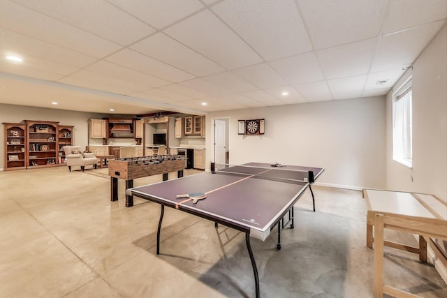 game room featuring recessed lighting, a drop ceiling, and concrete flooring