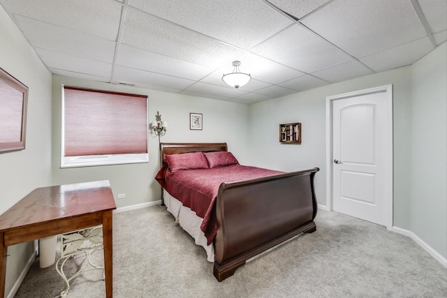 bedroom with a paneled ceiling, carpet, and baseboards