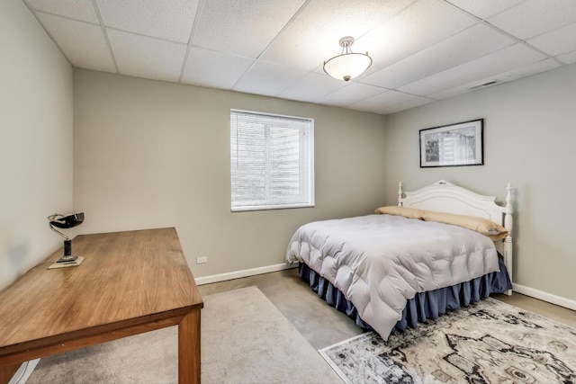 bedroom with a drop ceiling and baseboards