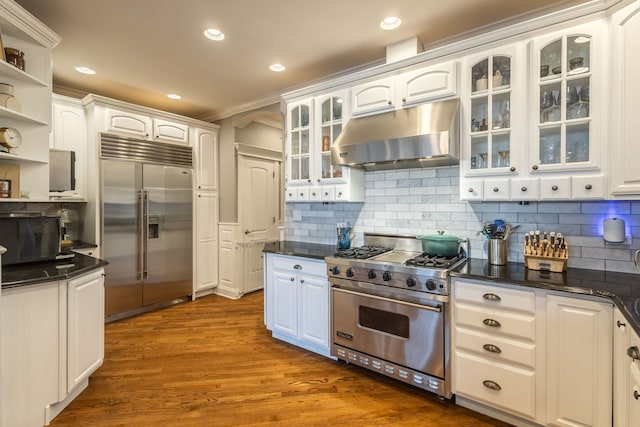 853 W Buckingham Pl Unit 4, Chicago, IL 60657 - kitchen with high end appliances, under cabinet range hood, white cabinets, open shelves, and glass insert cabinets