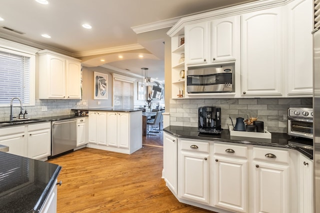853 W Buckingham Pl Unit 4, Chicago, IL 60657 - kitchen with stainless steel appliances, a sink, crown molding, tasteful backsplash, and white cabinets