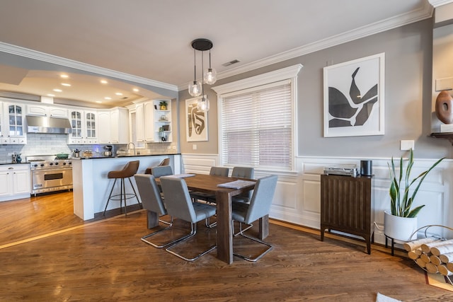 853 W Buckingham Pl Unit 4, Chicago, IL 60657 - dining area featuring crown molding, dark wood-style floors, a decorative wall, recessed lighting, and a wainscoted wall