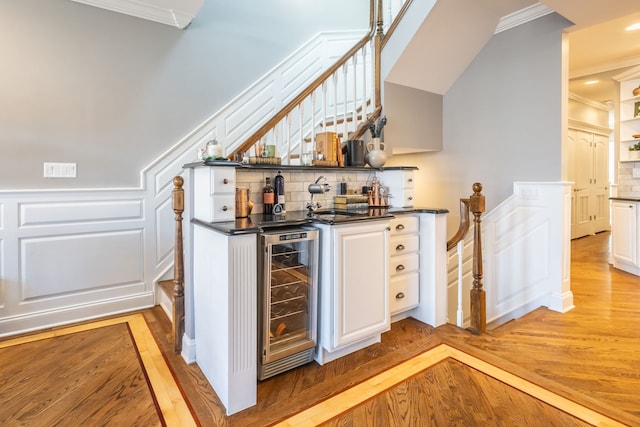 853 W Buckingham Pl Unit 4, Chicago, IL 60657 - indoor wet bar featuring beverage cooler, light wood finished floors, decorative backsplash, ornamental molding, and a decorative wall
