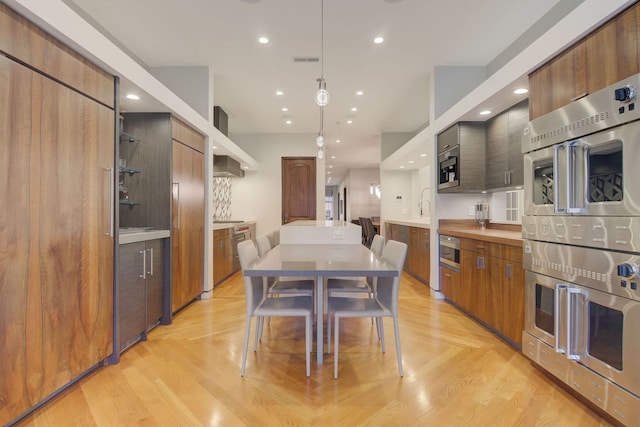 1942 N Cleveland Ave, Chicago, IL 60614 - kitchen featuring modern cabinets, wall chimney exhaust hood, recessed lighting, light countertops, and stainless steel double oven