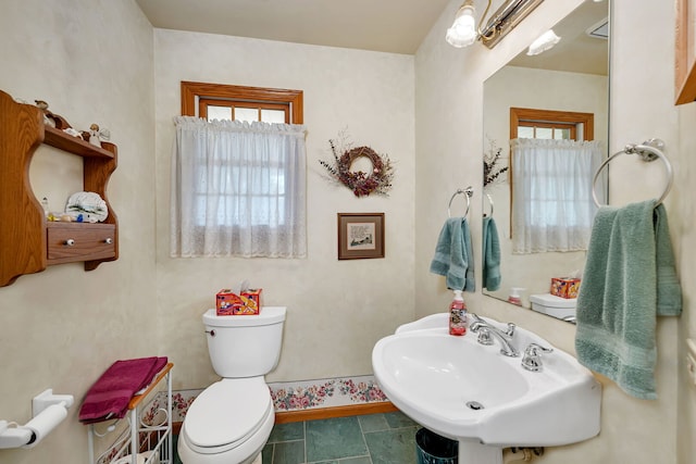 1002 Birchwood Ct, Morris, IL 60450 - bathroom featuring a sink, toilet, baseboards, and stone finish floors
