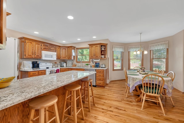 1002 Birchwood Ct, Morris, IL 60450 - kitchen with white appliances, a peninsula, a kitchen breakfast bar, light wood-style flooring, and recessed lighting
