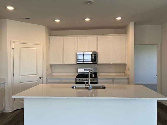 2611 Harnish Dr, Algonquin, IL 60102 - kitchen with stainless steel appliances, white cabinets, a center island with sink, dark wood-style floors, and recessed lighting