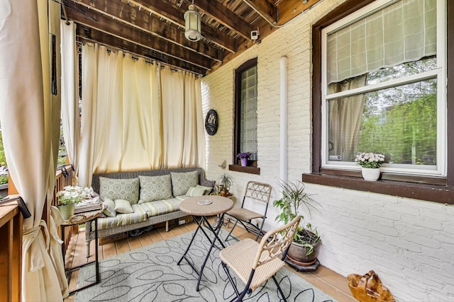 sunroom / solarium featuring an outdoor living space and beam ceiling