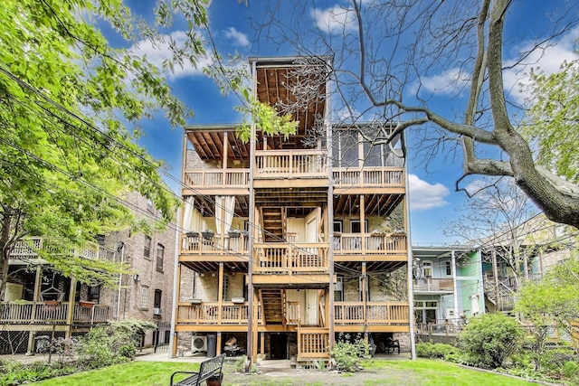 rear view of property featuring stairs, a wooden deck, stone siding, and a yard