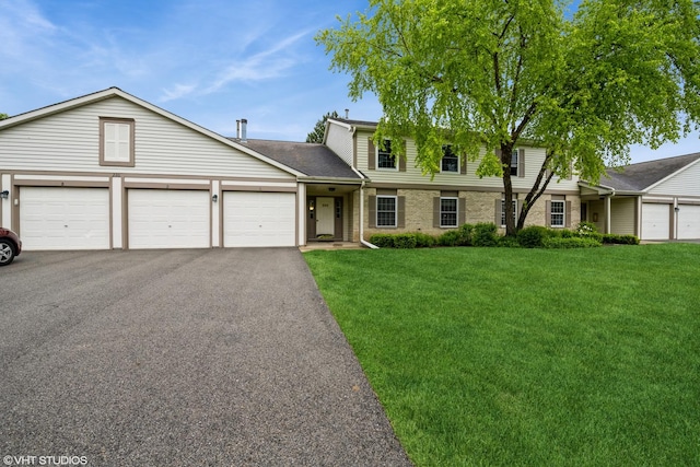 220 Wethington Dr Unit B, Wauconda, IL 60084 - traditional-style home featuring a front yard, asphalt driveway, an attached garage, brick siding, and roof with shingles