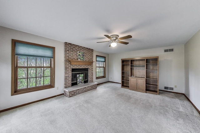 unfurnished living room featuring a ceiling fan, baseboards, carpet floors, and a fireplace