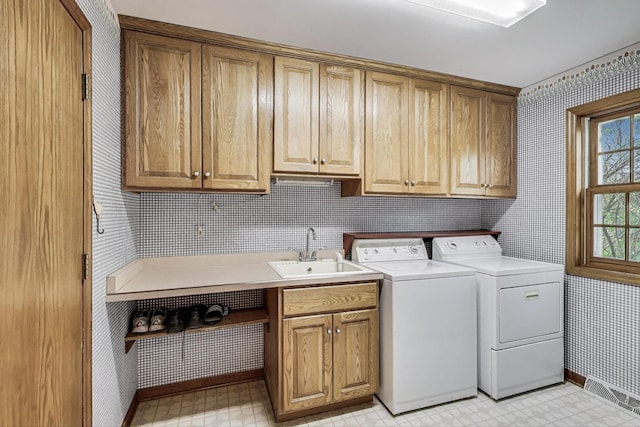 laundry area with wallpapered walls, cabinet space, independent washer and dryer, baseboards, and light floors