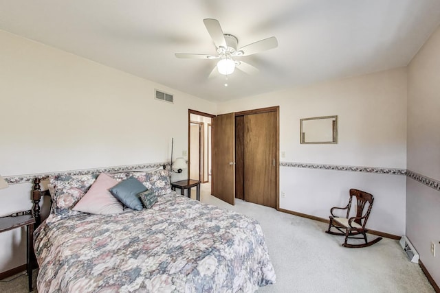 carpeted bedroom with a closet, baseboards, ceiling fan, and baseboard heating
