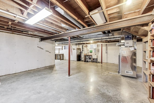 unfinished below grade area with water heater, heating unit, and a sink